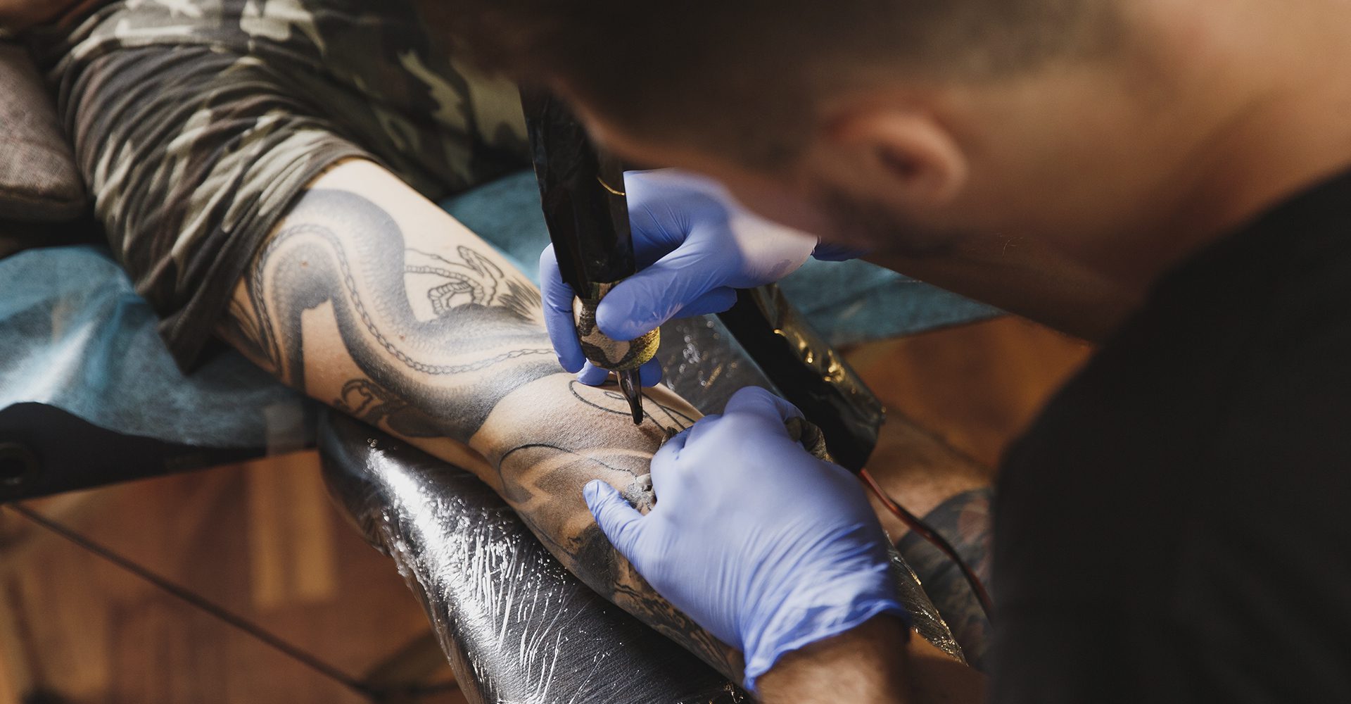 Homme tatouant un avant-bras