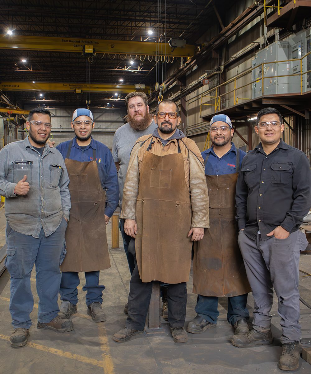 Groupe d'hommes recrutés par Equinox World travaillant dans une usine de métal